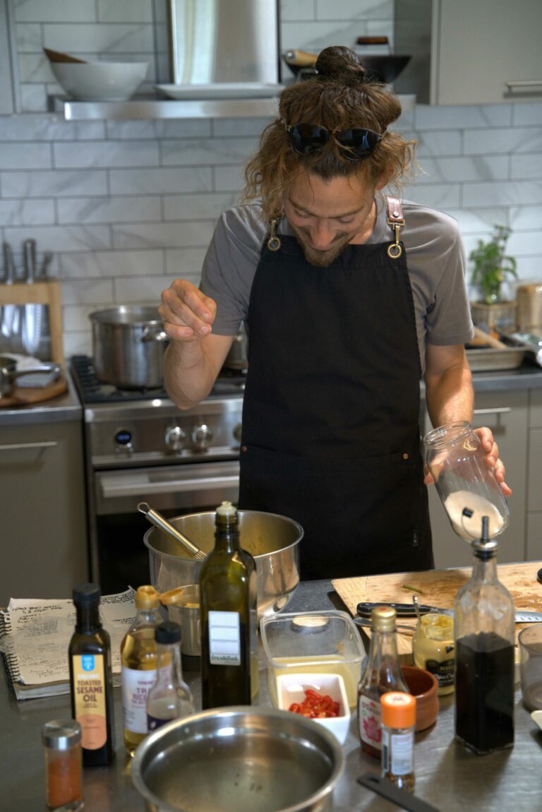 Chef sprinkling salt into a mixing bowl in a kitchen